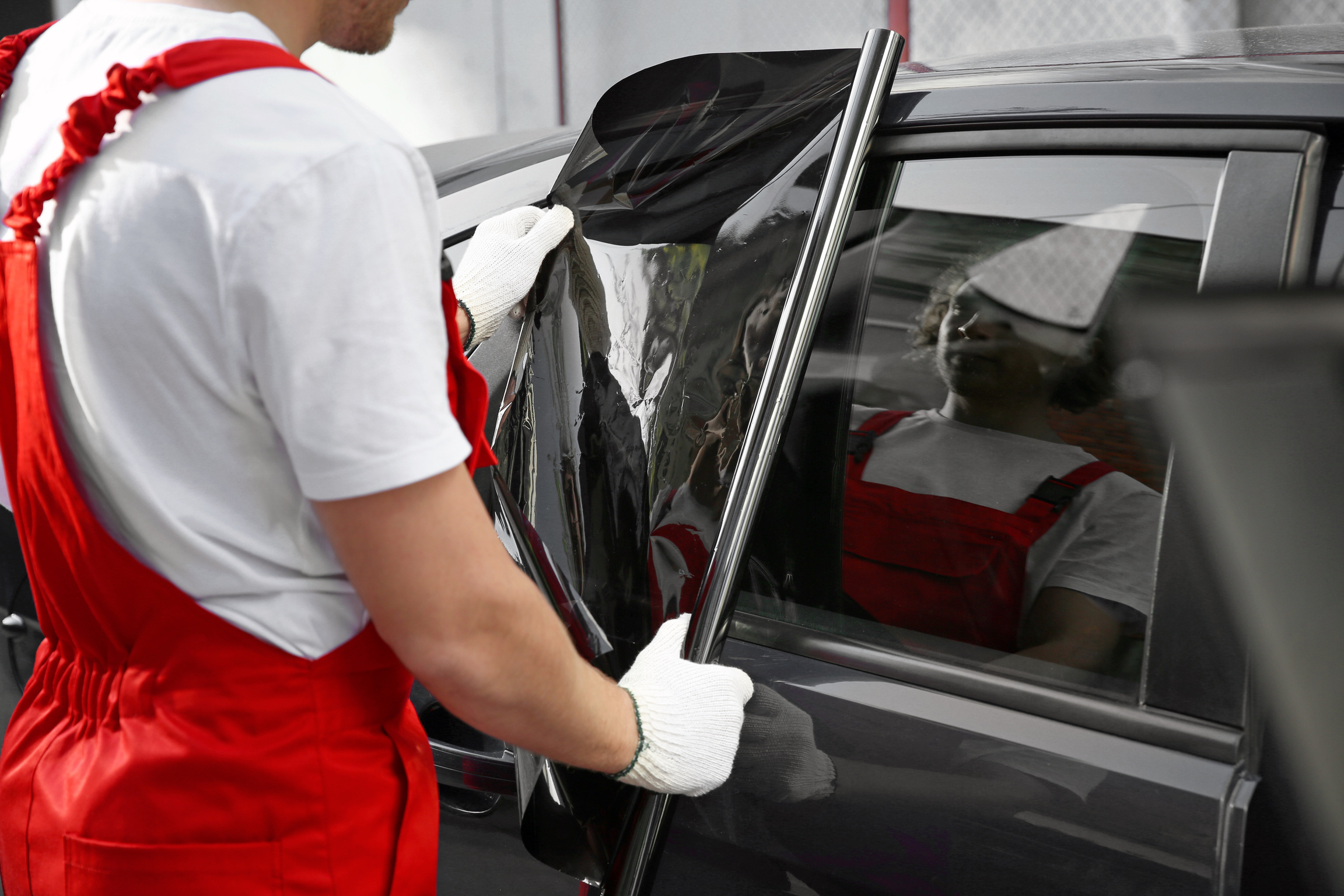 Male Worker Tinting Car Window Outdoors